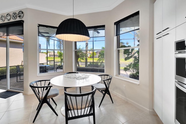 tiled dining space featuring a wealth of natural light and ornamental molding