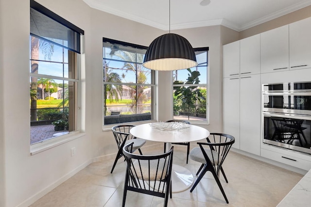 dining space featuring light tile patterned floors, a healthy amount of sunlight, and ornamental molding