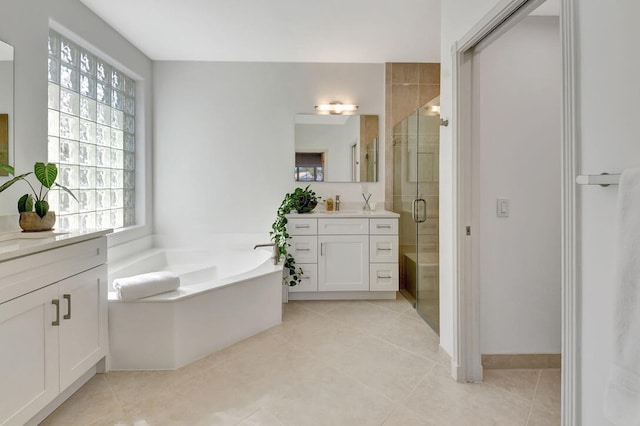 bathroom with vanity, tile patterned flooring, and plus walk in shower