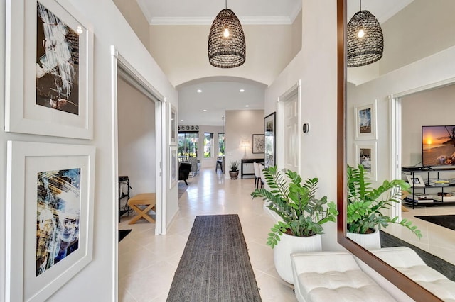 hallway with light tile patterned floors and crown molding