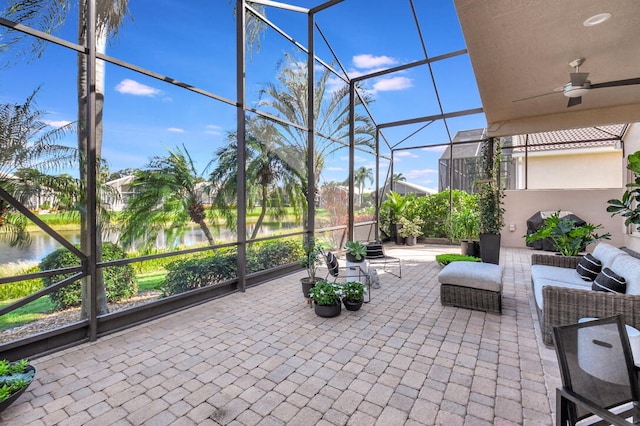 sunroom / solarium featuring a water view and ceiling fan