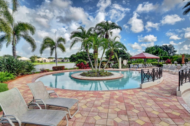 view of pool featuring a gazebo, a water view, and a patio