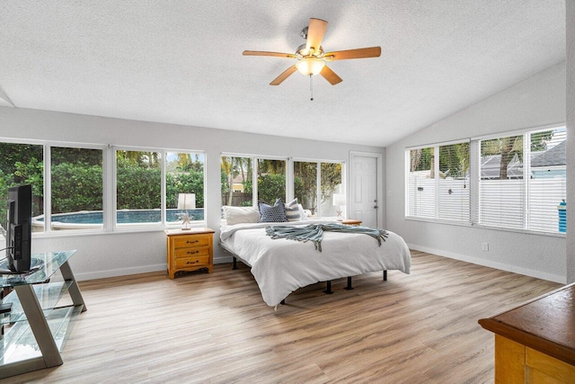 bedroom with vaulted ceiling, ceiling fan, hardwood / wood-style floors, and a textured ceiling