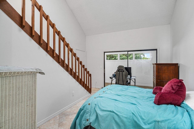 bedroom featuring lofted ceiling and a textured ceiling