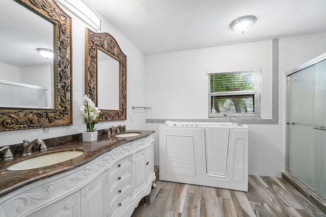 bathroom with vanity, plus walk in shower, tile walls, wood-type flooring, and washer / clothes dryer