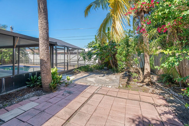 view of patio featuring a fenced in pool and glass enclosure