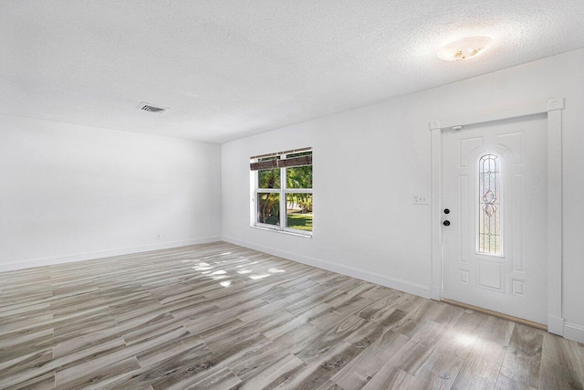 entrance foyer featuring a textured ceiling and light hardwood / wood-style floors