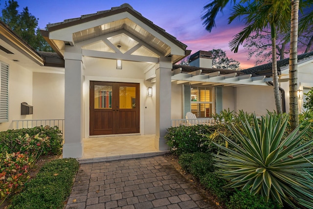 exterior entry at dusk featuring covered porch