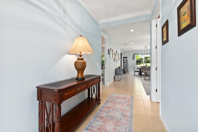 hallway with light tile patterned flooring and crown molding