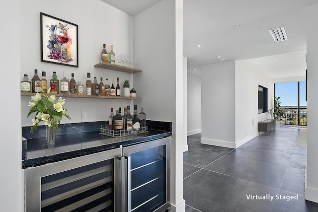 bar with beverage cooler, visible vents, baseboards, and a bar