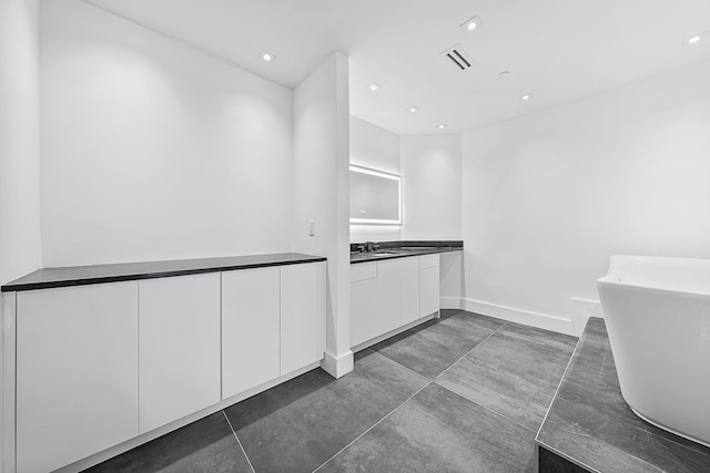 kitchen with recessed lighting, visible vents, white cabinets, dark countertops, and modern cabinets