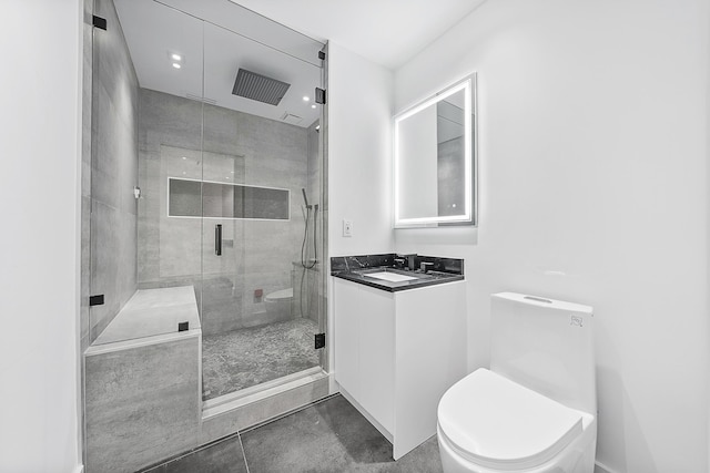 bathroom with tile patterned floors, vanity, toilet, and a shower with shower door