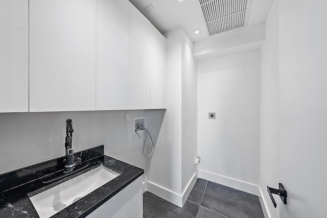 laundry room featuring cabinets, washer hookup, electric dryer hookup, sink, and dark tile patterned flooring