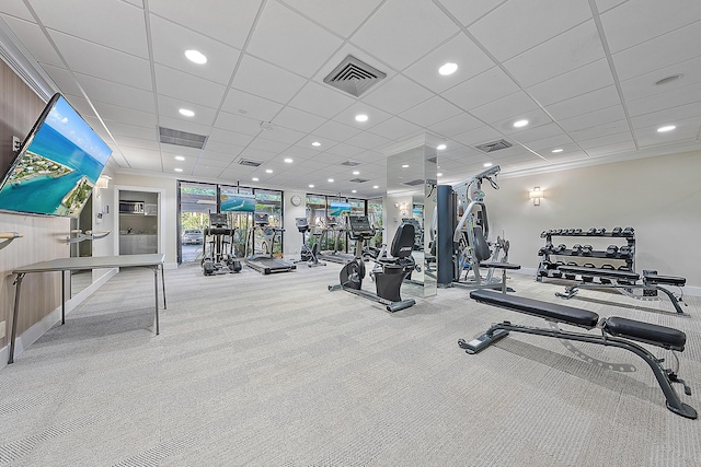 gym featuring ornamental molding and light carpet