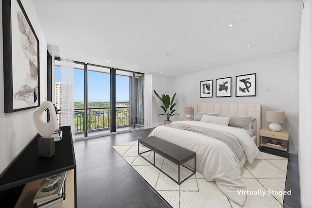 bedroom featuring access to outside, concrete floors, and floor to ceiling windows