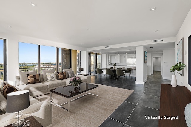 living room with recessed lighting, visible vents, and baseboards