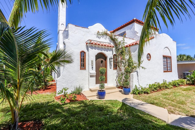 mediterranean / spanish-style home with a front lawn