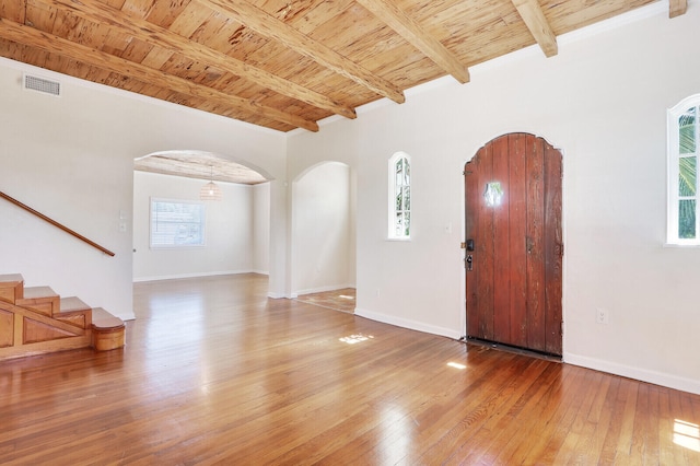 entryway featuring beamed ceiling, a healthy amount of sunlight, brick ceiling, and wood-type flooring