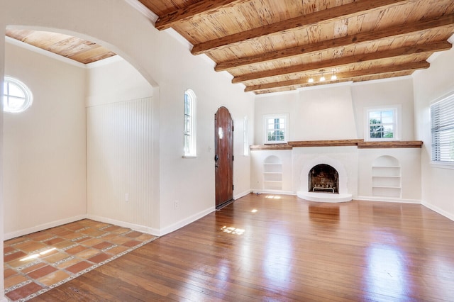 unfurnished living room with built in shelves, wood ceiling, beamed ceiling, and hardwood / wood-style flooring