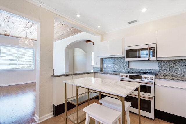 kitchen with pendant lighting, double oven range, decorative backsplash, white cabinets, and stone counters