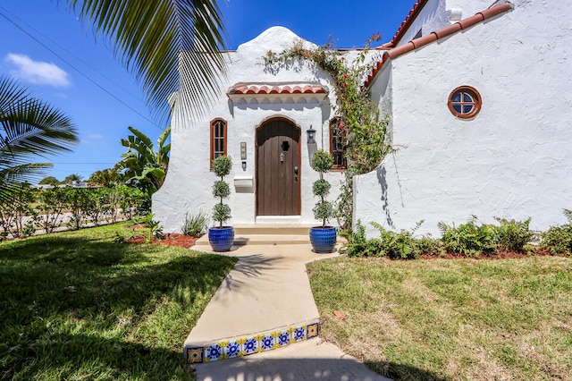 entrance to property featuring a lawn