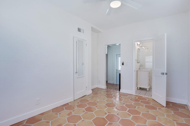 tiled empty room featuring ceiling fan