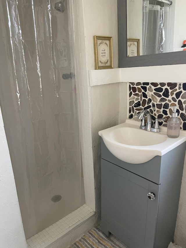 bathroom featuring vanity, walk in shower, and tasteful backsplash