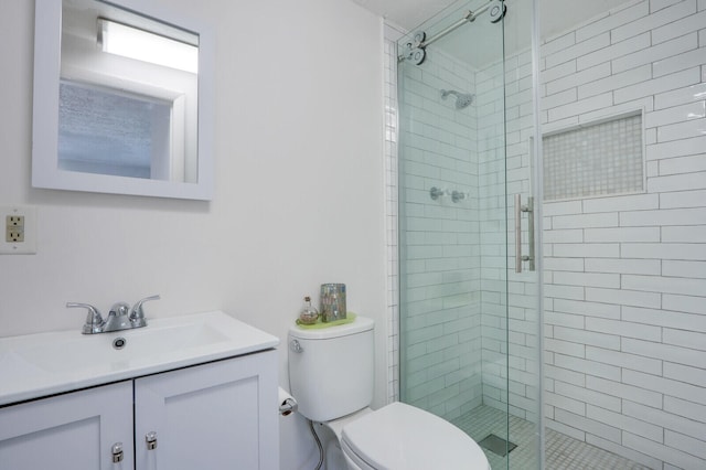 bathroom featuring toilet, a shower with door, and vanity