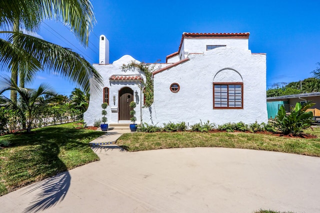 mediterranean / spanish-style home with a front lawn