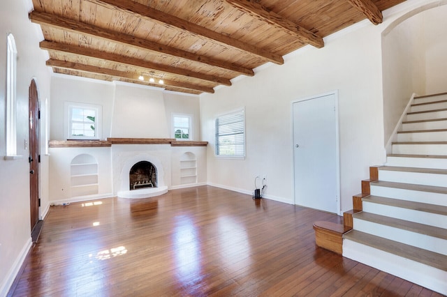 unfurnished living room featuring dark hardwood / wood-style flooring, wooden ceiling, and beamed ceiling