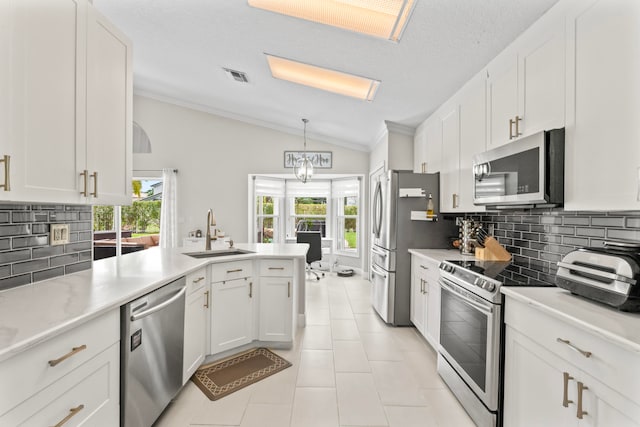 kitchen featuring sink, white cabinets, vaulted ceiling, and appliances with stainless steel finishes