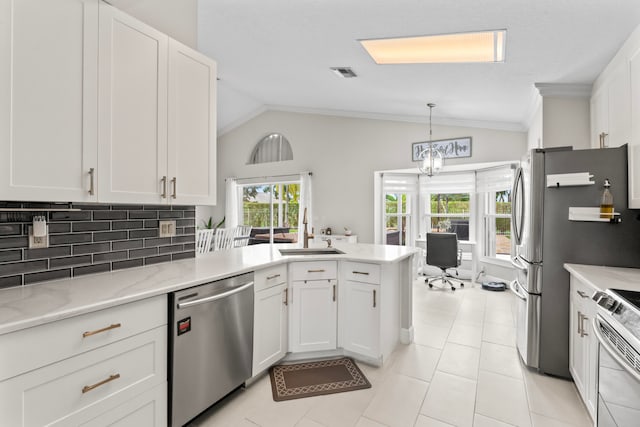 kitchen featuring white cabinetry, sink, tasteful backsplash, vaulted ceiling, and appliances with stainless steel finishes