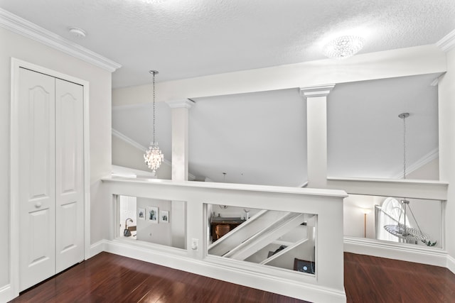 details featuring wood-type flooring, a textured ceiling, an inviting chandelier, and ornamental molding