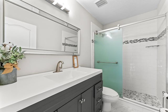 bathroom featuring a textured ceiling, vanity, toilet, and a shower with door