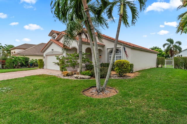 mediterranean / spanish-style house featuring a front yard and a garage