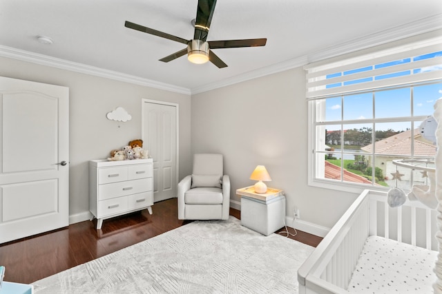 bedroom featuring hardwood / wood-style flooring, ceiling fan, a crib, and ornamental molding