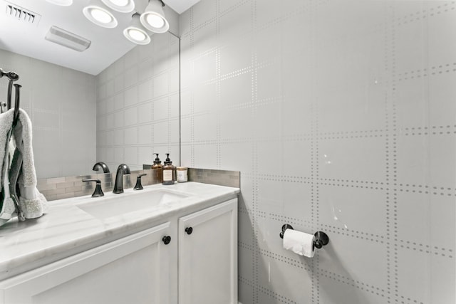 bathroom featuring tasteful backsplash, vanity, and tile walls