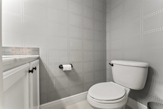 bathroom featuring tile patterned floors, toilet, and tile walls