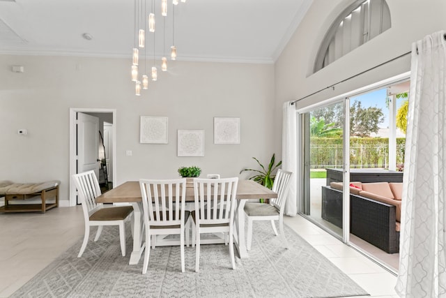 dining room featuring light tile patterned floors, a towering ceiling, and ornamental molding