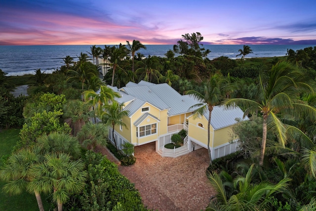 aerial view at dusk featuring a water view