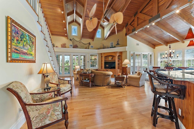 living room with beam ceiling, a wealth of natural light, wooden ceiling, and light wood-type flooring