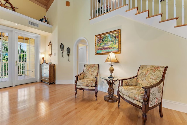 sitting room with a high ceiling and hardwood / wood-style flooring