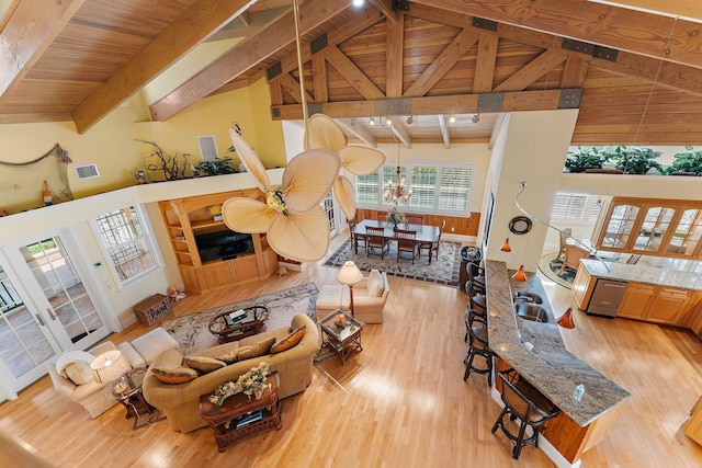 living room featuring beam ceiling, high vaulted ceiling, light hardwood / wood-style flooring, and wooden ceiling