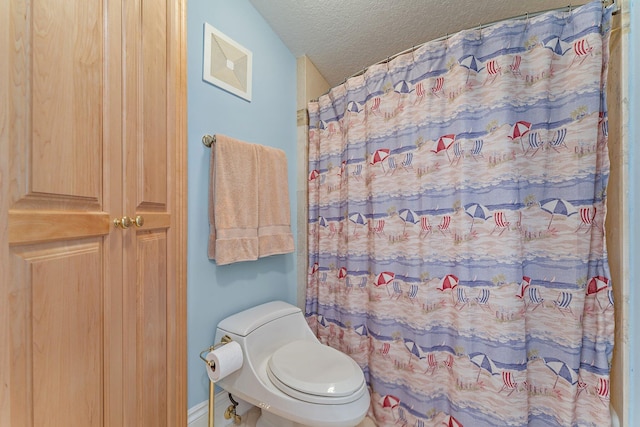 bathroom with toilet and a textured ceiling