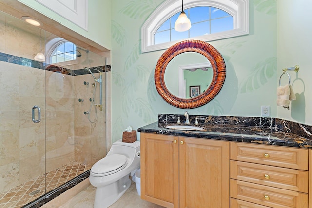 bathroom featuring tile patterned flooring, vanity, an enclosed shower, and toilet