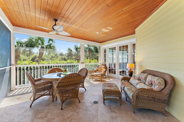 sunroom / solarium with ceiling fan, wooden ceiling, and french doors