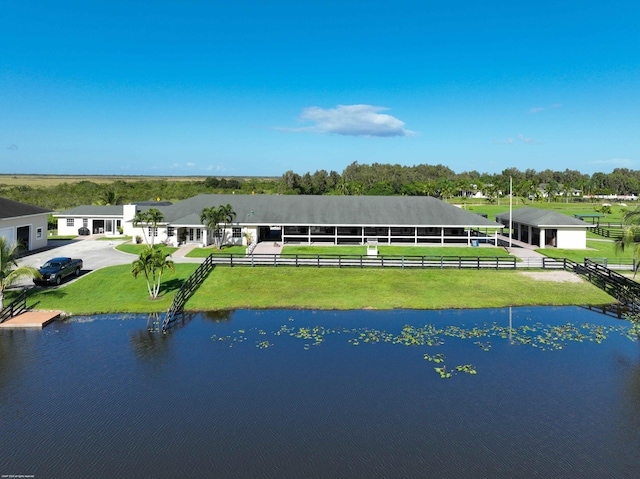 rear view of property featuring a water view and a yard