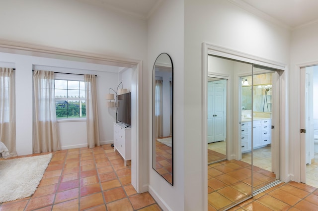 hallway with ornamental molding and light tile patterned flooring