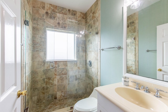 bathroom with toilet, vanity, and an enclosed shower