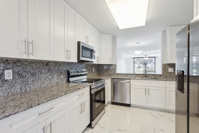 kitchen featuring tasteful backsplash, white cabinets, stone countertops, and appliances with stainless steel finishes